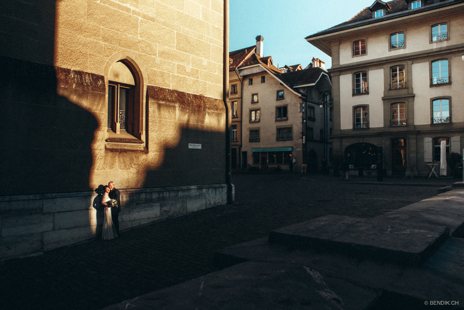 Lachendes Brautpaar wird von einem Sonnenstrahl in der Berner Altstadt beleuchtet