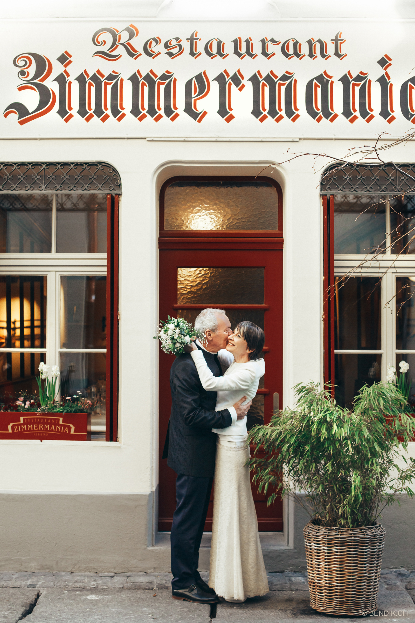 Brautpaar umarmt sich lachend vor Restaurant in Berner Innenstadt